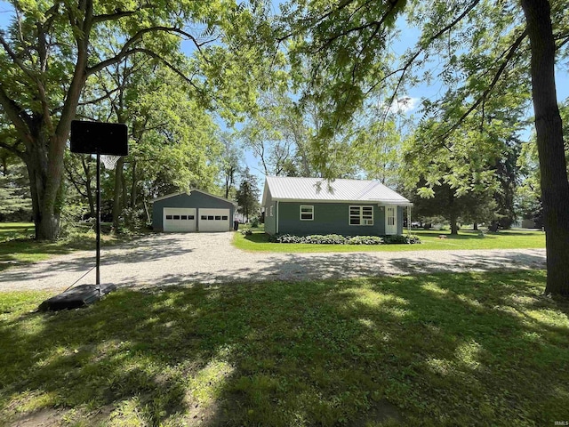 view of front of home with a front yard, a garage, and an outdoor structure