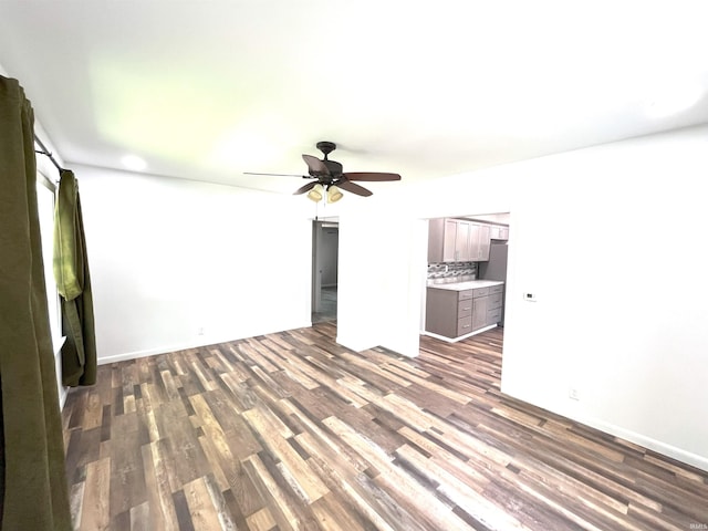 unfurnished living room with dark hardwood / wood-style flooring and ceiling fan