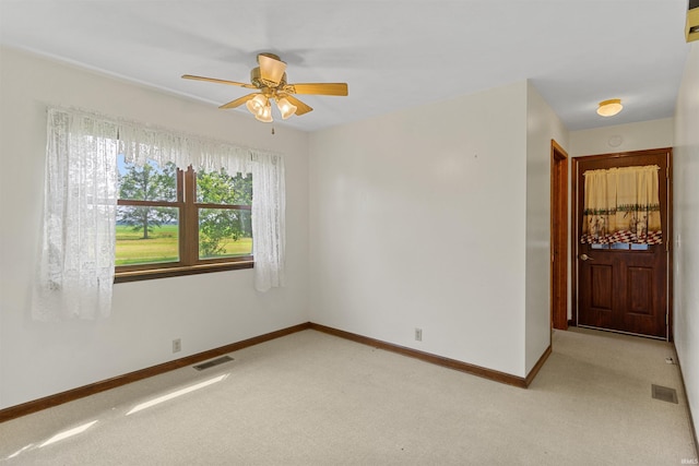 carpeted spare room with ceiling fan