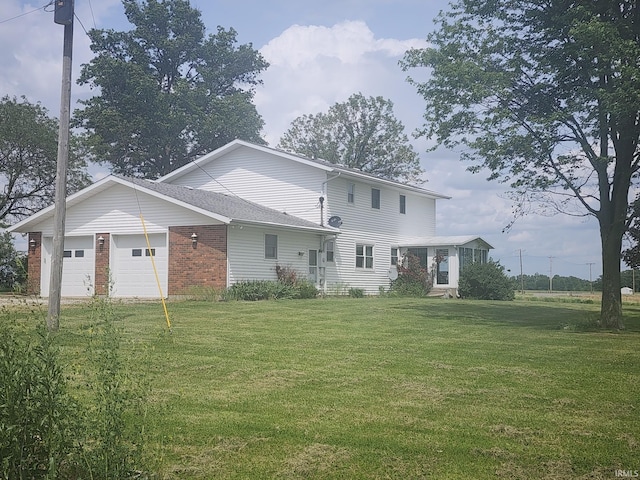 back of property featuring a lawn and a garage