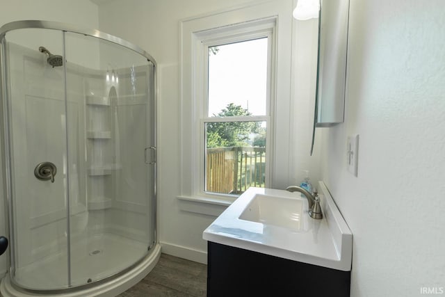 bathroom featuring vanity, hardwood / wood-style flooring, and a shower with door