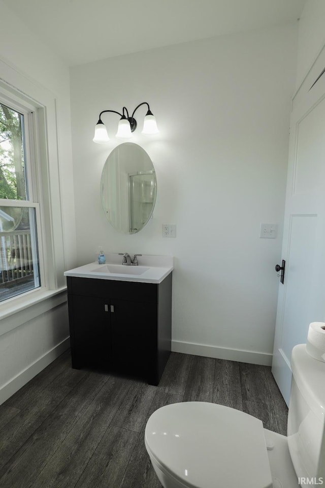 bathroom featuring oversized vanity, toilet, and wood-type flooring