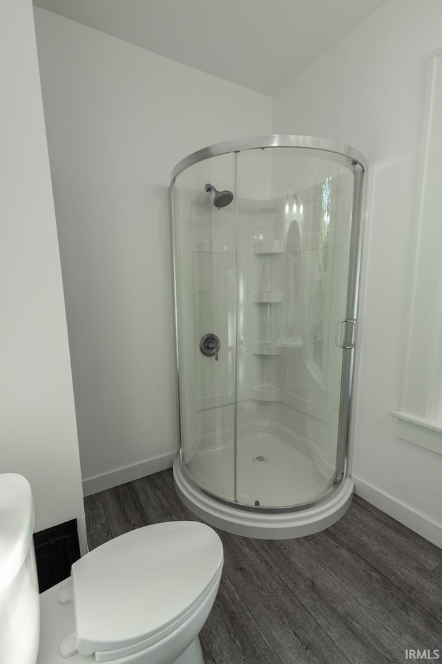 bathroom with a shower with door, wood-type flooring, and toilet