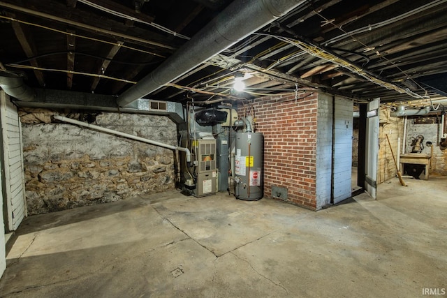 basement featuring brick wall, gas water heater, and heating utilities