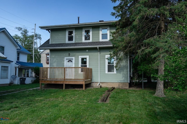 rear view of property featuring a lawn and a wooden deck