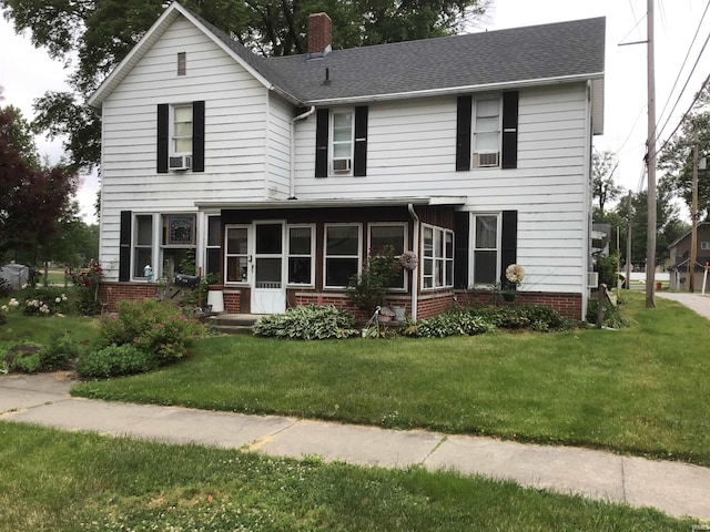 view of front of house with cooling unit and a front yard