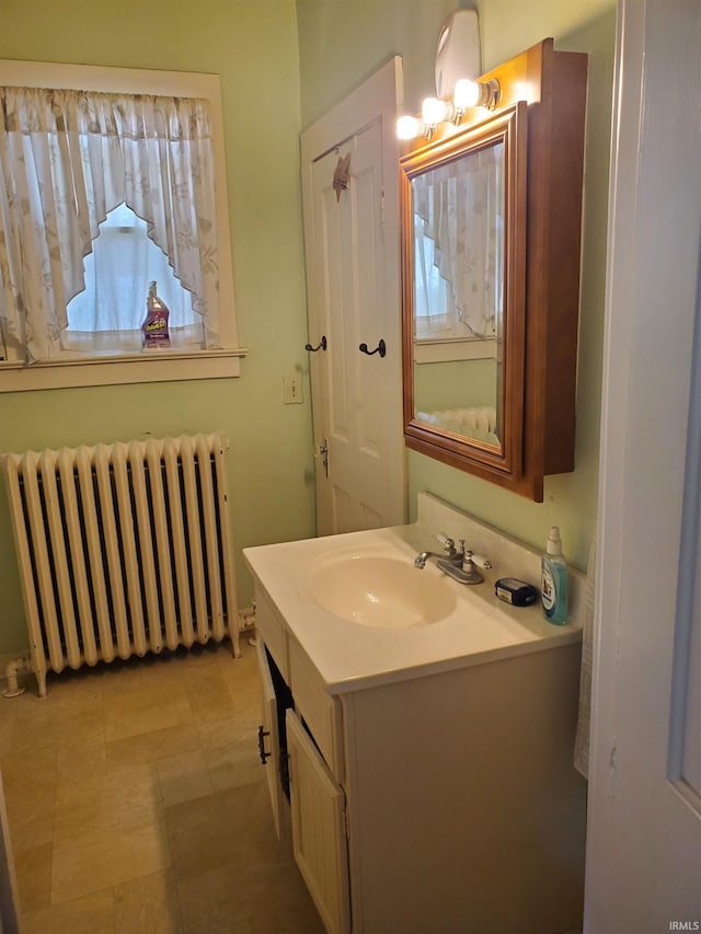 bathroom with radiator heating unit, vanity, and tile patterned floors