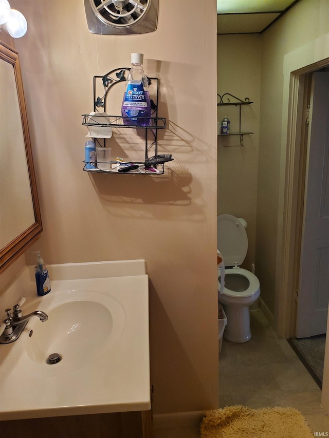 bathroom with toilet, tile patterned flooring, and vanity