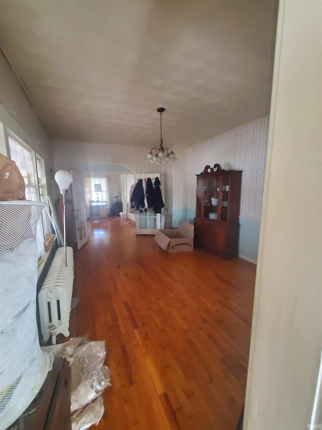 unfurnished dining area with a notable chandelier and hardwood / wood-style flooring