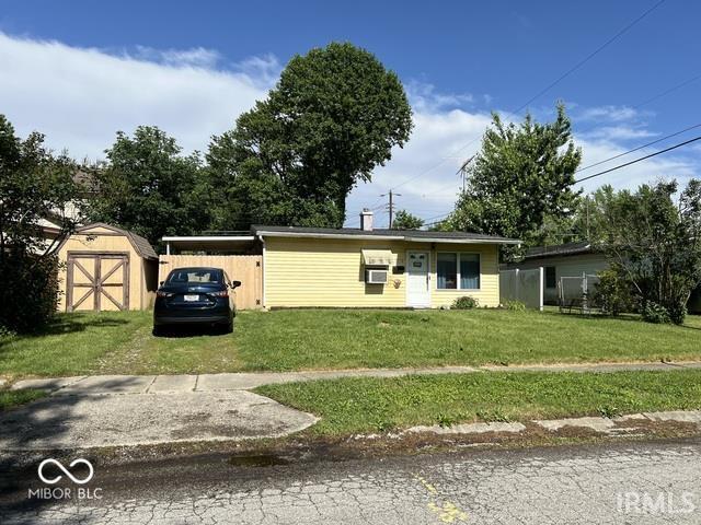 view of front of property with a storage unit and a front yard