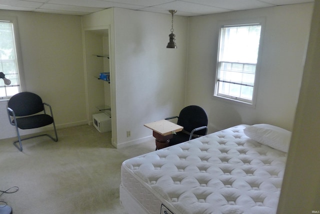 bedroom with light colored carpet and a drop ceiling