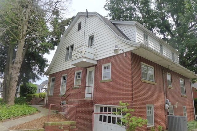 view of side of home with a garage and central AC