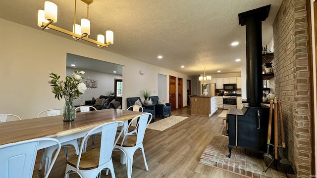 0 N State Road 450, Shoals, IN 47581 - dining space with a wood stove, a textured ceiling, light wood-type flooring, a chandelier, and recessed lighting