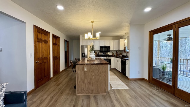 0 N State Road 450, Shoals, IN 47581 - kitchen with black appliances, wood finished floors, white cabinets, baseboards, and a textured ceiling