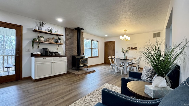 0 N State Road 450, Shoals, IN 47581 - living area featuring a wood stove, a chandelier, a textured ceiling, wood finished floors, and baseboards