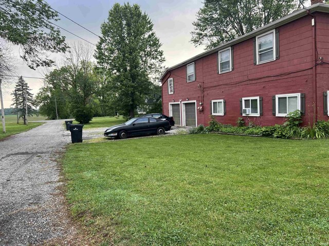 view of property exterior with a garage and a yard