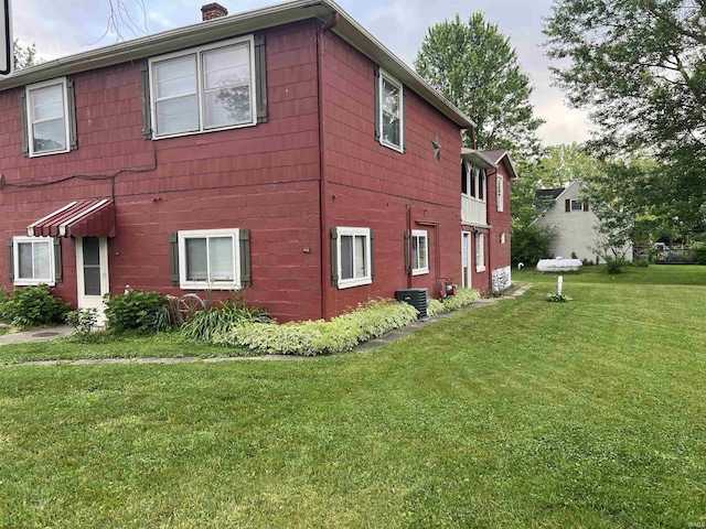 view of property exterior featuring a yard and central AC