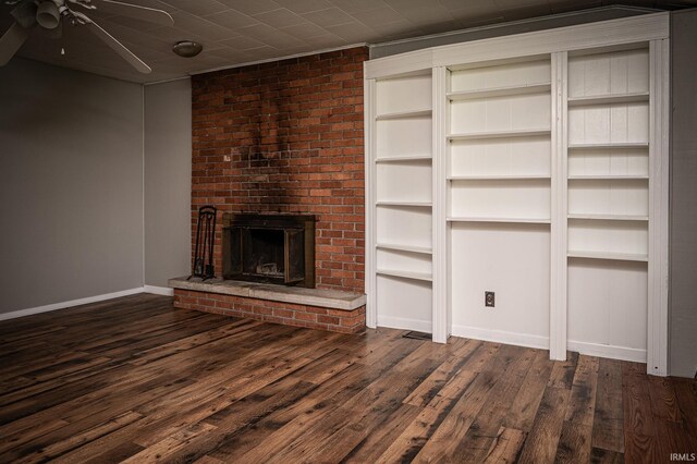 unfurnished living room with a fireplace, dark hardwood / wood-style flooring, and ceiling fan