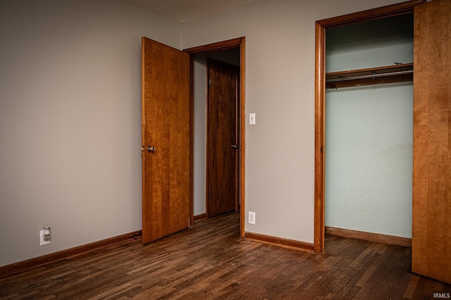 unfurnished bedroom with a closet and dark hardwood / wood-style flooring