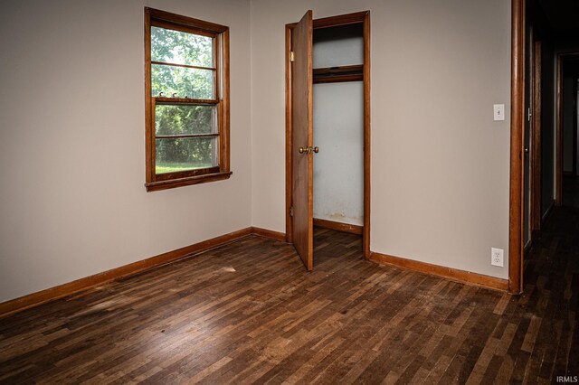 unfurnished bedroom featuring dark hardwood / wood-style floors and a closet