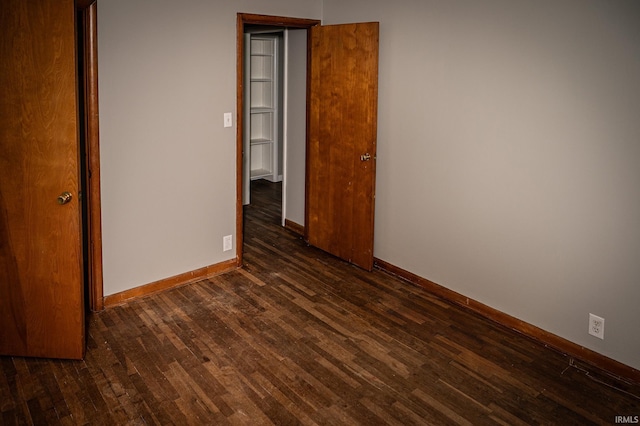 unfurnished room with dark hardwood / wood-style flooring