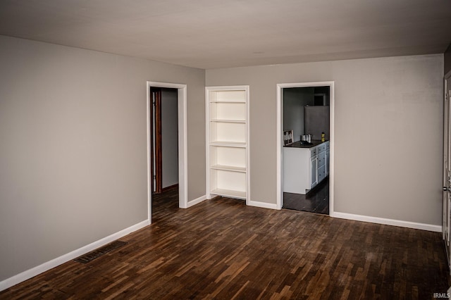 unfurnished bedroom featuring dark hardwood / wood-style floors and a closet