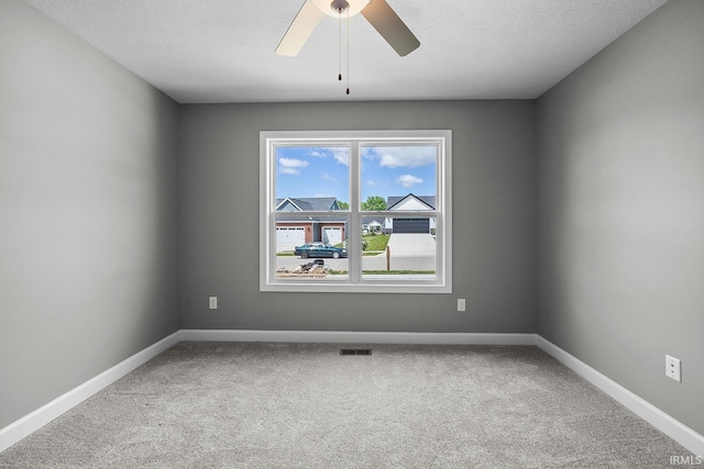 carpeted empty room featuring a textured ceiling and ceiling fan