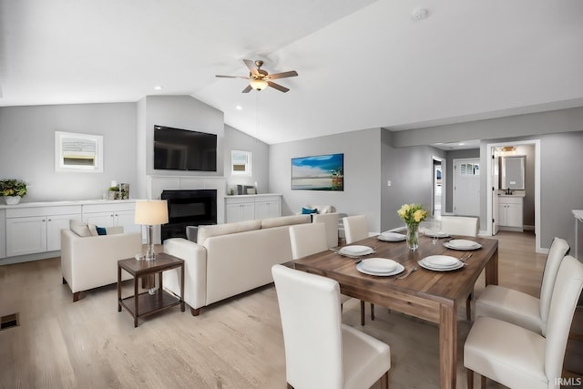 dining room featuring sink, ceiling fan, light wood-type flooring, and lofted ceiling