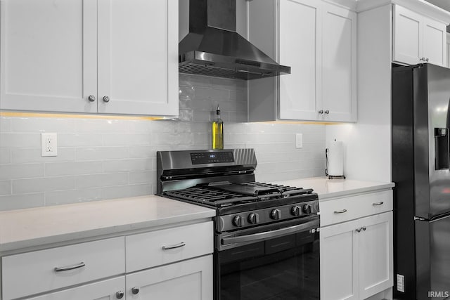 kitchen with white cabinetry, wall chimney range hood, stainless steel appliances, and decorative backsplash