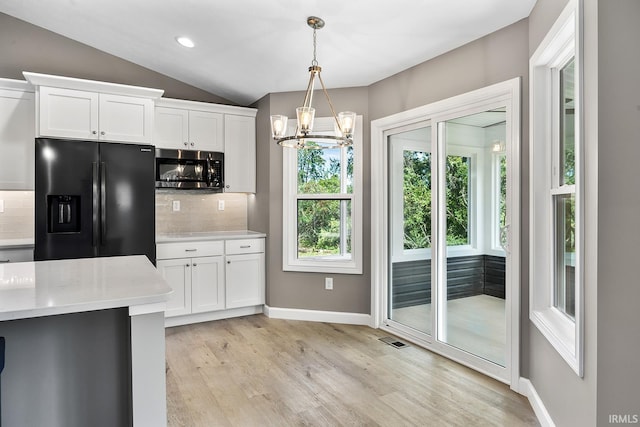 kitchen with light hardwood / wood-style flooring, tasteful backsplash, vaulted ceiling, black refrigerator with ice dispenser, and white cabinetry