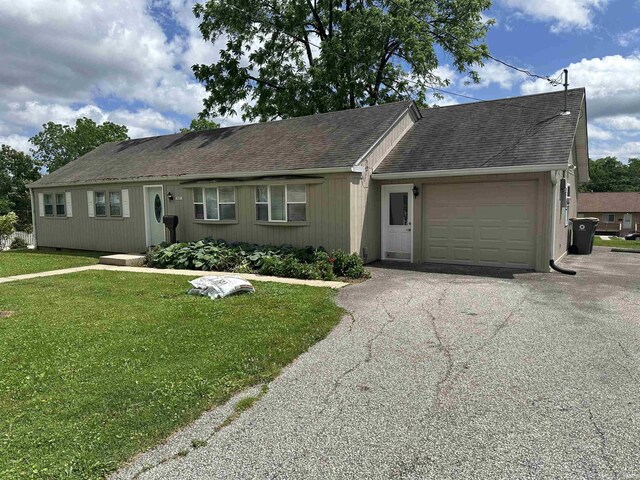 single story home featuring a front lawn and a garage