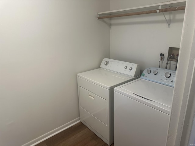 washroom featuring laundry area, dark wood-style flooring, washing machine and dryer, and baseboards