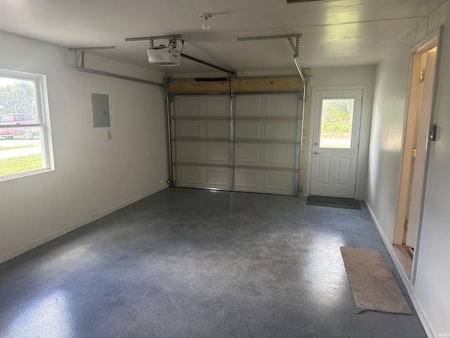 garage featuring a garage door opener, electric panel, and baseboards