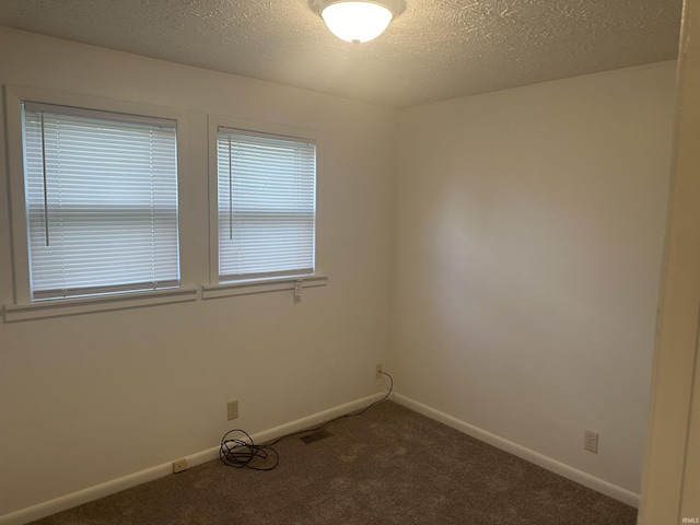 carpeted empty room with visible vents, baseboards, and a textured ceiling