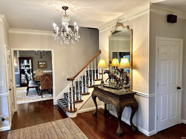 entryway featuring a chandelier, dark wood-type flooring, and ornamental molding