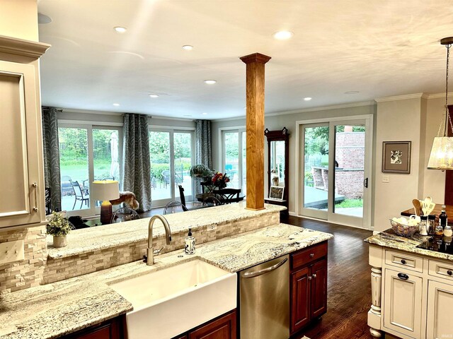 kitchen featuring dishwasher, dark wood-type flooring, sink, hanging light fixtures, and ornate columns