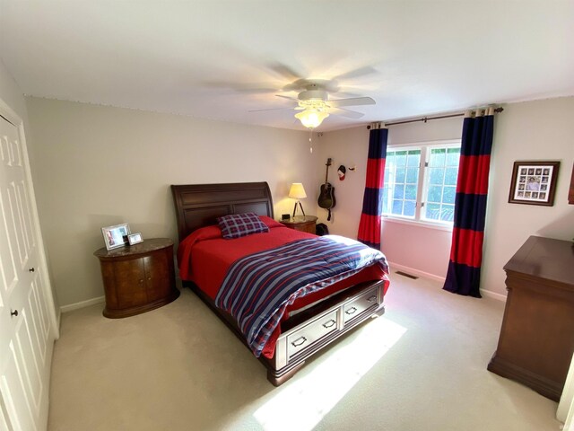 carpeted bedroom with ceiling fan and a closet