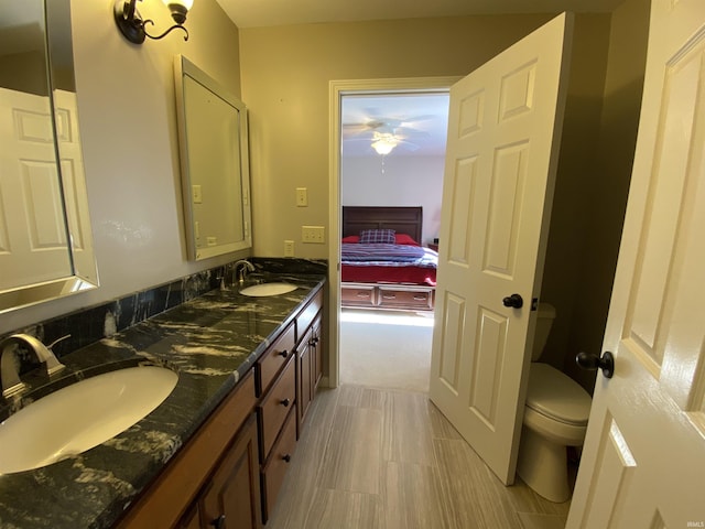 bathroom featuring vanity, toilet, and ceiling fan