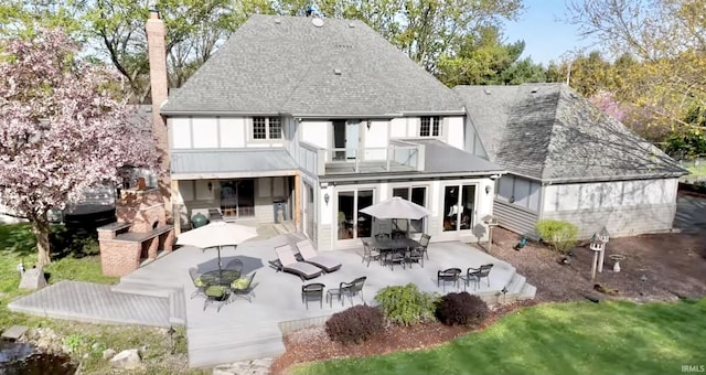 rear view of property featuring a fireplace and a patio