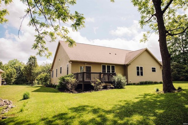 rear view of property featuring a deck and a lawn