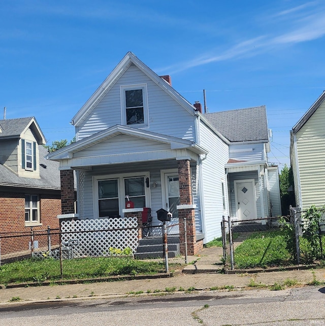 view of front of house featuring a fenced front yard, a gate, and a porch