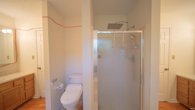 bathroom featuring vanity, wood-type flooring, and walk in shower