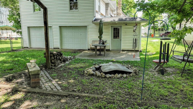 back of house with a lawn and a garage