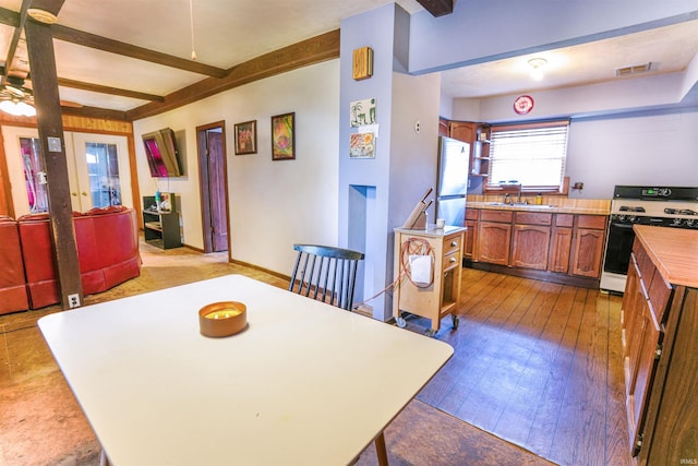 dining room featuring beamed ceiling, light hardwood / wood-style floors, ceiling fan, and sink