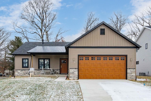 view of front of house with stone siding, covered porch, concrete driveway, metal roof, and a garage