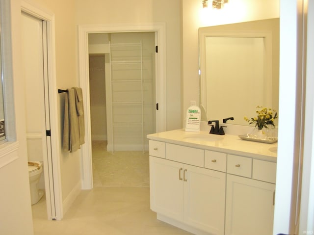 bathroom featuring tile patterned flooring, vanity, and toilet