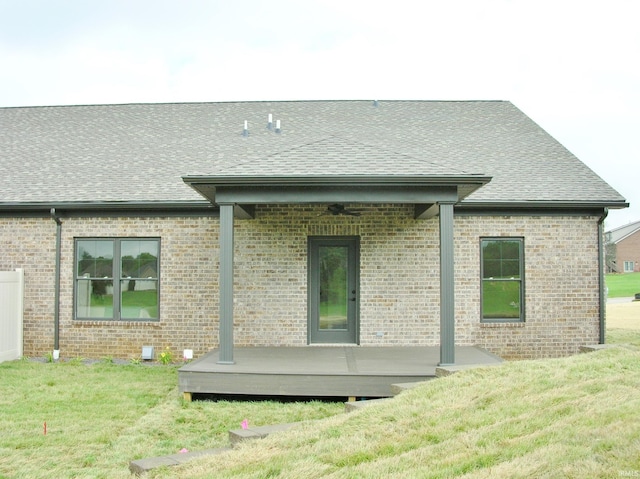 back of property featuring a yard and a wooden deck