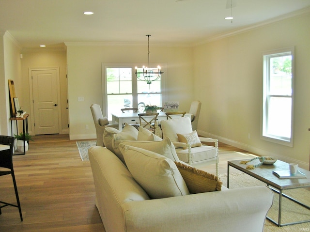 living room featuring crown molding, an inviting chandelier, and light wood-type flooring