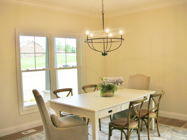 dining space featuring hardwood / wood-style floors, ornamental molding, and a chandelier