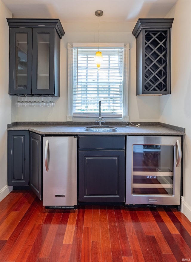 bar with dishwasher, dark wood-type flooring, beverage cooler, and pendant lighting